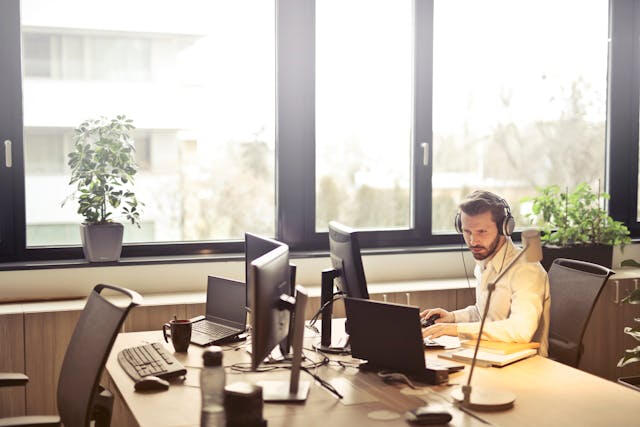 Website maintenance and care plans – Minneapolis freelance web designer Freelance web designer at desk with headset, providing website care and support plans