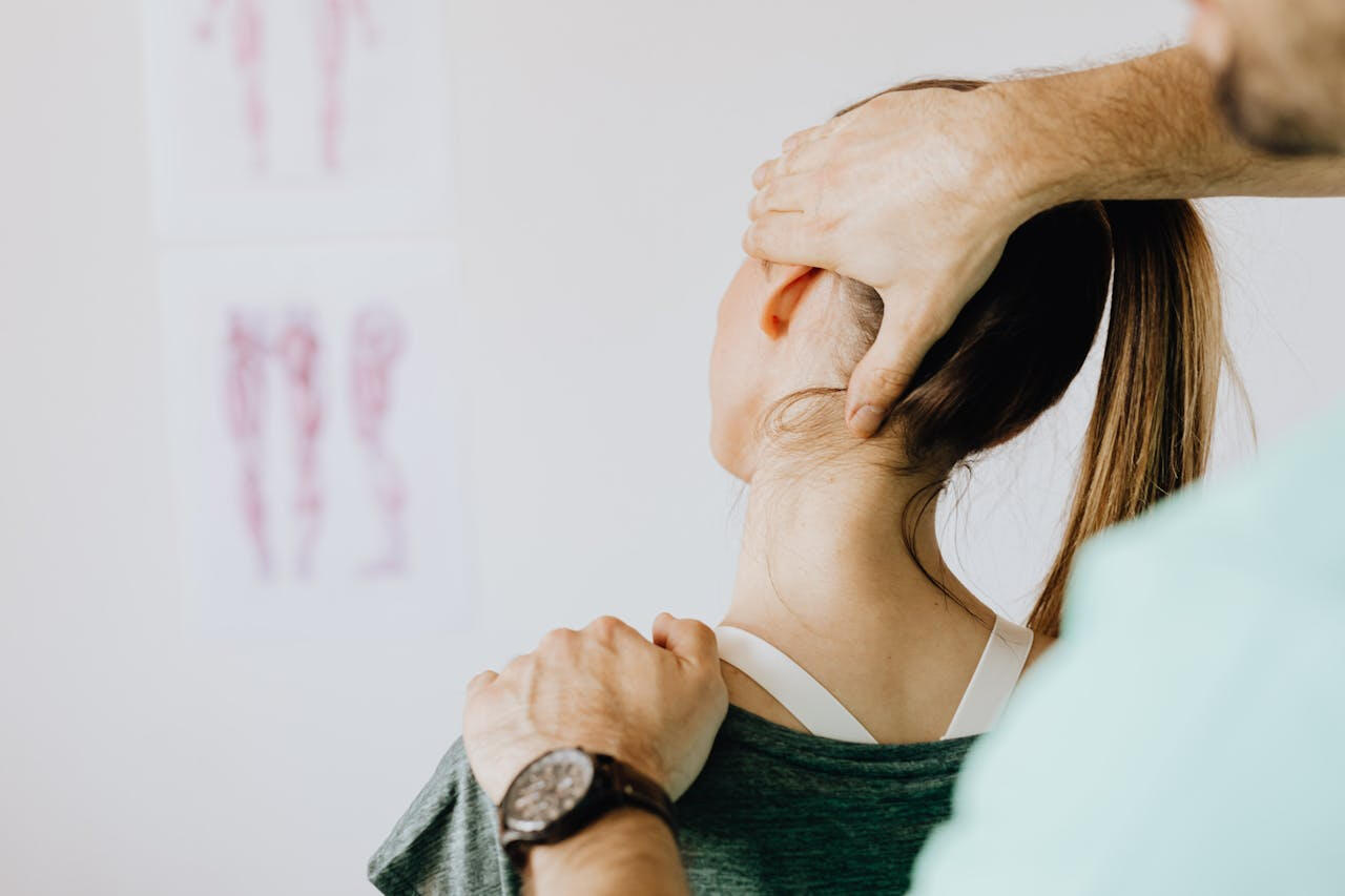 Chiropractic clinic website redesign – Minneapolis freelance designer Chiropractor adjusting a woman’s neck, representing chiropractic website audit and redesign project